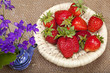 Bouquet of flowers in a ceramic teapot and strawberries in a wic