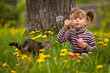Funny lovely little girl and a cat, blowing soap bubbles