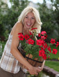 Foto: Portrait of a beautiful blonde with a pot of flowers Portrait of a beautiful blonde with a pot of flowers