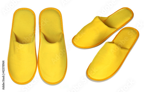 Photo: Pair of yellow house slippers isolated on white Pair of yellow house slippers isolated on white