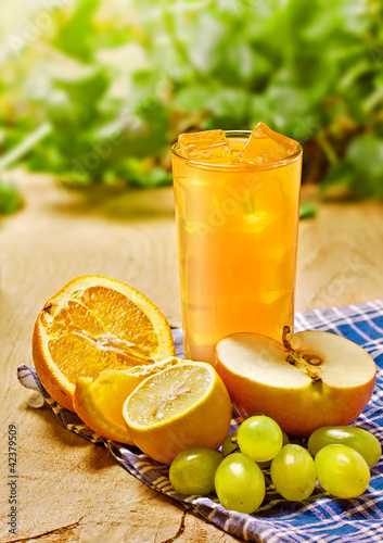 Photo: Juice, orange, apple, grape and lemon on the table, outdoor Juice, orange, apple, grape and lemon on the table, outdoor
