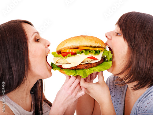Photo: Women eating hamburger. Women eating hamburger.