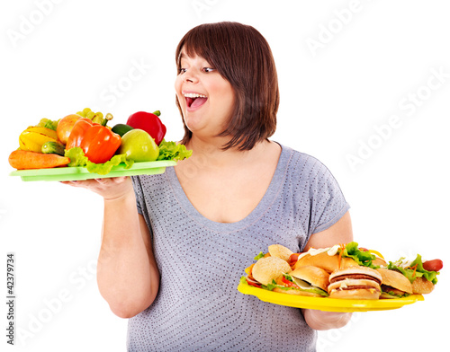 Foto: Woman choosing between fruit and hamburger. Woman choosing between fruit and hamburger.