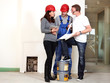 Architect, worker and customer making plans in building lot
