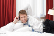 Mann telefoniert im Hotelzimmer