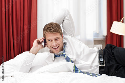 Photo: Mann telefoniert im Hotelzimmer Mann telefoniert im Hotelzimmer