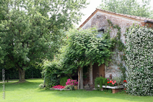 Photo: old rural house with garden flowers and Jasmine old rural house with garden flowers and Jasmine