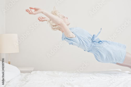 Photo: Junge Frau springt ins Bett Junge Frau springt ins Bett