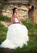 Photo: Smiling beautiful bride looking back over her shoulder, outdoor Smiling beautiful bride looking back over her shoulder, outdoor