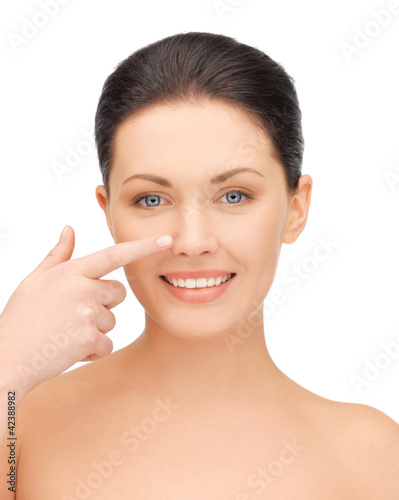 Foto: beautiful woman pointing to nose beautiful woman pointing to nose