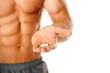 Photo: Close up of muscular man torso with hand full of pills Close up of muscular man torso with hand full of pills