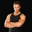 Photo: Happy fit male posing over black background Happy fit male posing over black background