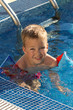 A little boy swims in the pool