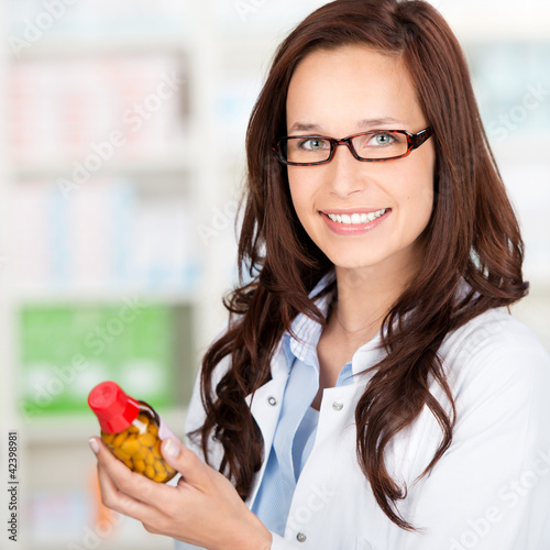 Photo: lächelnde apothekerin mit medikament lächelnde apothekerin mit medikament