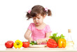 Little girl cutting vegetable for salad. Concept of healthy food