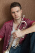 Photo: Handsome man hloding on a silver trumpet Handsome man hloding on a silver trumpet