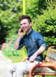 Photo: Happy young man in park with telephone Happy young man in park with telephone