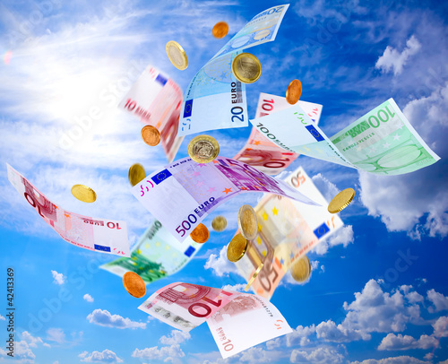 Photo: Euro banknotes and coins falling from blue sky Euro banknotes and coins falling from blue sky