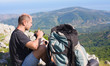 Foto: tourist on top of a mountain takes a snapshot of the nature tourist on top of a mountain takes a snapshot of the nature