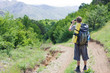 Foto: tourist on forest road takes a snapshot of the nature tourist on forest road takes a snapshot of the nature