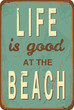 Vintage style tin sign with text "Life is good at the Beach".