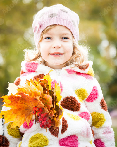 Photo: Child with bunch of maple leaves Child with bunch of maple leaves