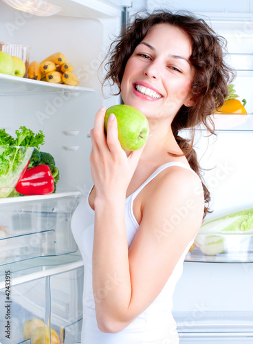 Foto: Beautiful Young Woman near the Refrigerator with healthy food Beautiful Young Woman near the Refrigerator with healthy food