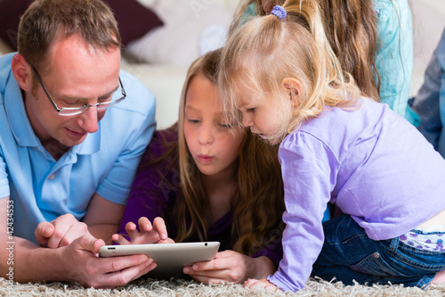 Photo: Familie spielt mit dem Tablet computer daheim Familie spielt mit dem Tablet computer daheim
