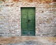 green wooden door on brick wall