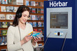 Frau in Buchhandlung hoert Hörbuch