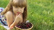Child eating cherries lying on the grass