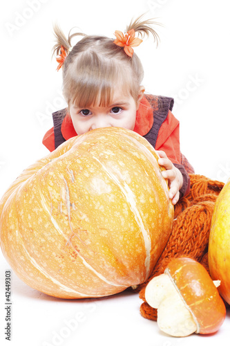 Photo: little girl in an orange vest plays with big pumpkins little girl in an orange vest plays with big pumpkins