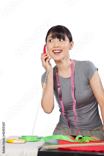 Photo: Woman Dressmaker on Phone Woman Dressmaker on Phone