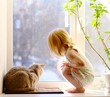 Cat and girl looking out of the window