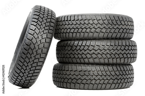 Photo: Stack of four car wheel winter tires isolated Stack of four car wheel winter tires isolated
