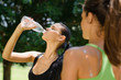 Two young women relaxing after fitness in park