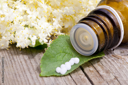 Foto: Homöopathisches Medikament mit Holunderblüten Homöopathisches Medikament mit Holunderblüten