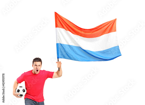 Foto: An euphoric fan holding a ball and waving a dutch flag An euphoric fan holding a ball and waving a dutch flag