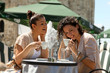 Young smiling women drinking a coffee and sitting in a cafe