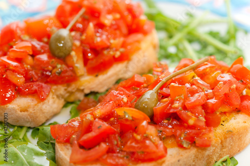 Photo: Fresh bruscjhetta with tomato, basil and caper. Fresh bruscjhetta with tomato, basil and caper.