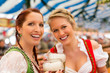 Photo: Junge Frauen in traditionellem Dirndl in einem Bierzelt Junge Frauen in traditionellem Dirndl in einem Bierzelt
