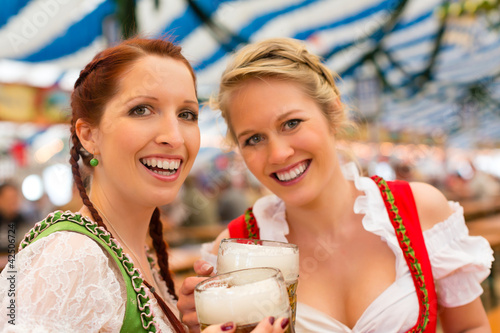 Photo: Junge Frauen in traditionellem Dirndl in einem Bierzelt Junge Frauen in traditionellem Dirndl in einem Bierzelt