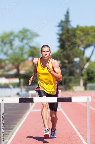 Foto: Male Track and Field Athlete during Obstacle Race Male Track and Field Athlete during Obstacle Race