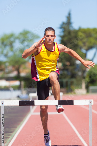 Photo: Male Track and Field Athlete during Obstacle Race Male Track and Field Athlete during Obstacle Race