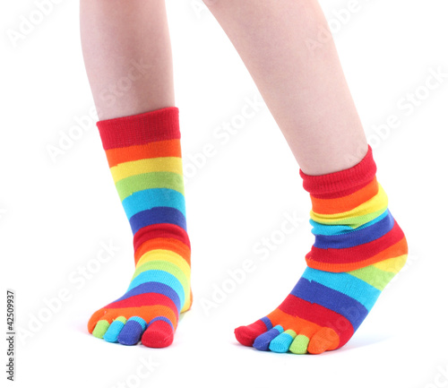 Foto: female legs in colorful striped socks isolated on white female legs in colorful striped socks isolated on white