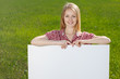 Smiling woman holding blank whiteboard