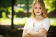 Beautiful girl standing with folded hands over summer background
