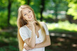 Smiling girl standing with folded hands over summer background