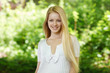 Closeup of young smiling woman on background of summer nature