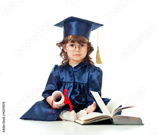 Photo: Little girl kid in academician clothes with book Little girl kid in academician clothes with book